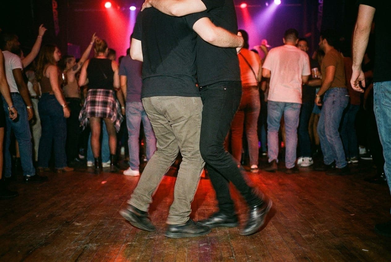 A couple dancing salsa in a dimly lit New York club.