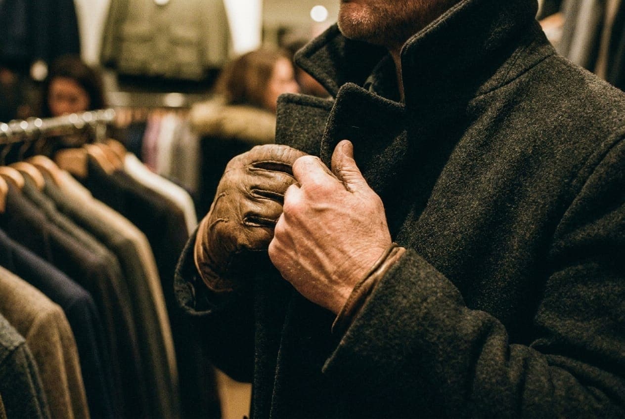 A rack of carefully curated men's shirts and jackets inside a well-lit New York boutique.