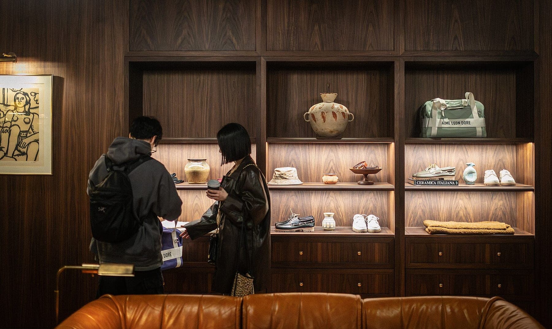 Customers inspect bag in Aimé Leon Dore Store interior