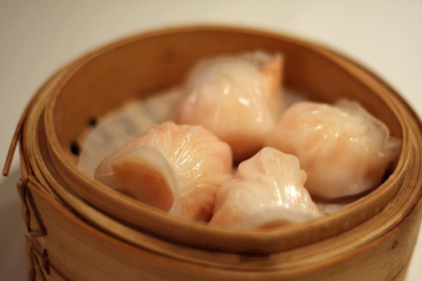 Several shrimp dumplings in a bamboo steamer
