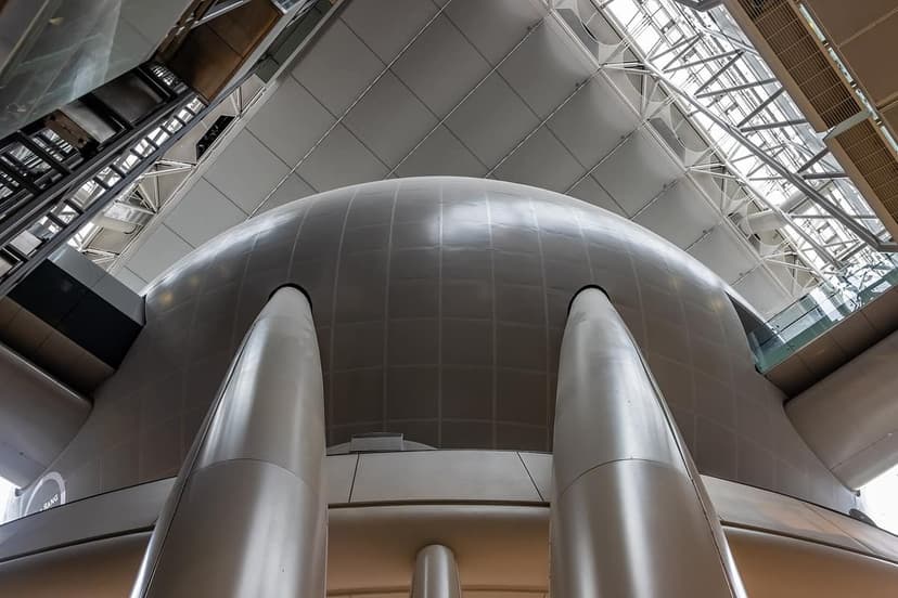 A low angle view looking up at the large, smooth, grey spherical Hayden Big Bang Theater inside the American Museum of Natural History.