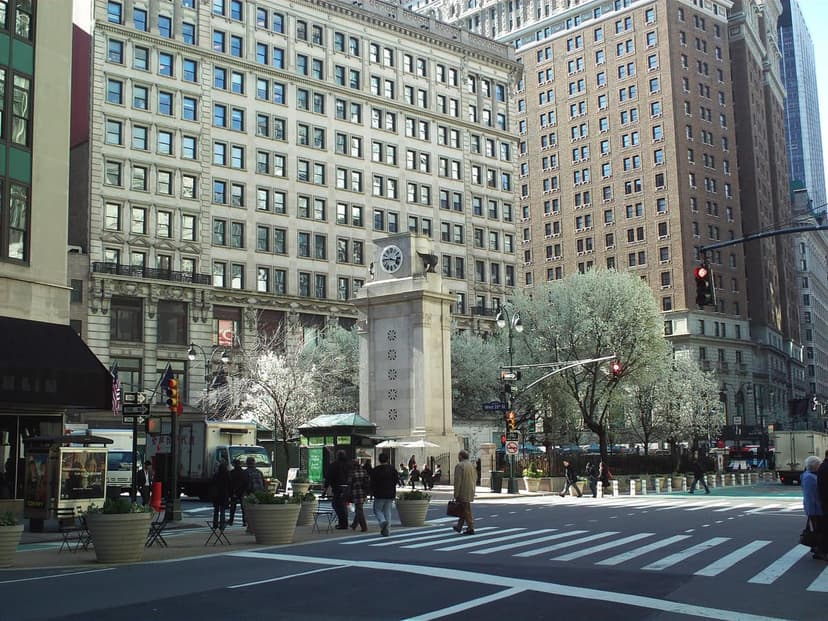 A street view of Herald Square in Midtown Manhattan with the James Gordon Bennett Memorial clock tower, surrounding office buildings,