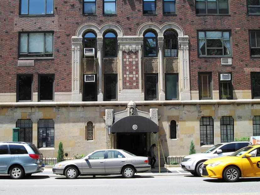 The east facade of 444 Central Park West, an apartment building with brick and stone details, arched windows, and a street level entrance.