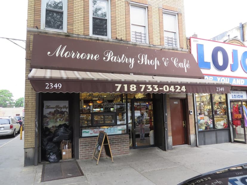 Exterior view of Morrone Pastry Shop & Cafe with a brown awning and sign, located next to a store named LOJOM.