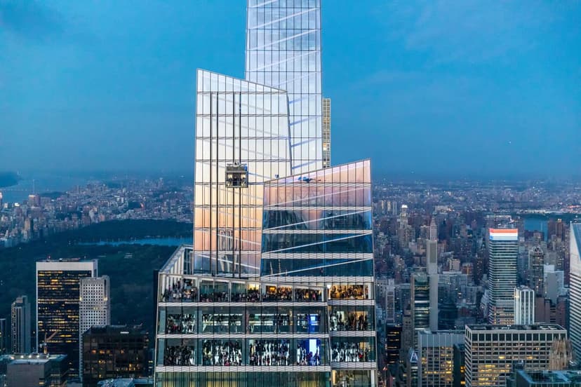 Modern glass skyscraper with multiple floors of people visible inside, overlooking a city skyline and Central Park at dusk.