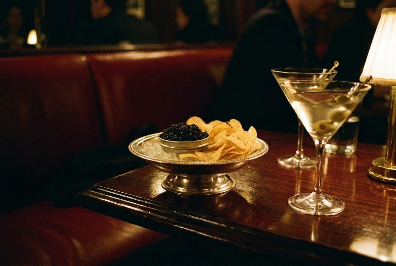 A candlelit table at Romy in SoHo featuring housemade potato chips and caviar under dim lighting.